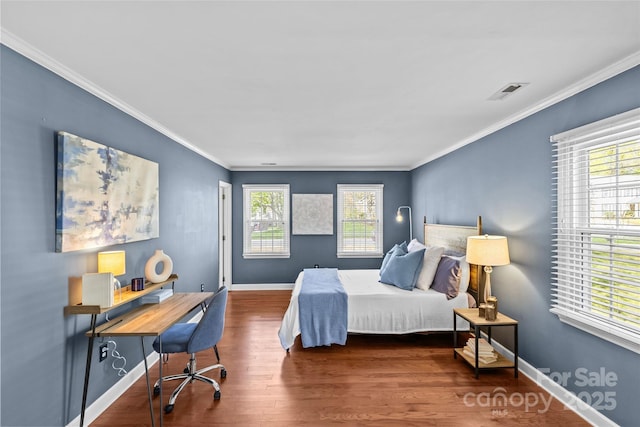 bedroom with baseboards, crown molding, and wood finished floors