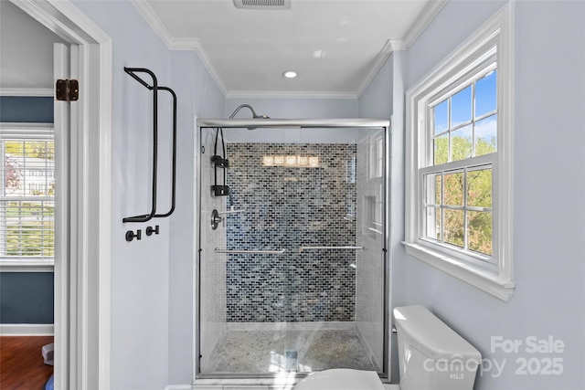 full bathroom with a stall shower, crown molding, toilet, baseboards, and visible vents
