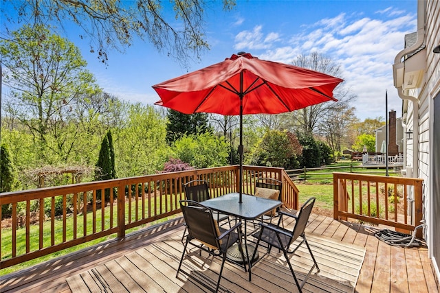 deck with a lawn and outdoor dining space