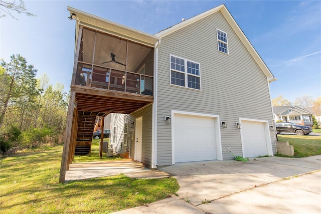 exterior space with an attached garage, stairway, a ceiling fan, driveway, and a yard