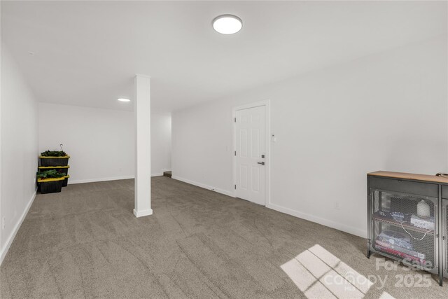 below grade area with baseboards and carpet flooring