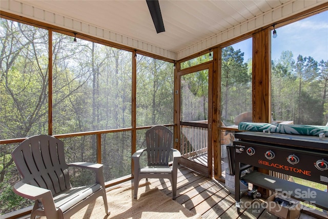 sunroom with a wooded view