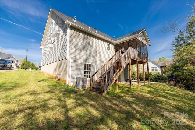 back of house with a yard, a sunroom, central air condition unit, and stairs