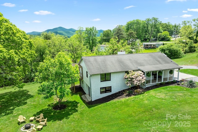 9 Mikayla Ln, Candler, NC 28715 - view of side of property featuring a lawn, an outdoor fire pit, a mountain view, a shingled roof, and a chimney