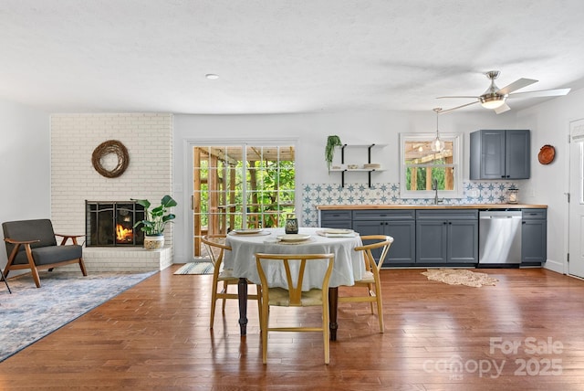 9 Mikayla Ln, Candler, NC 28715 - dining space featuring healthy amount of natural light, wood finished floors, a ceiling fan, and a brick fireplace