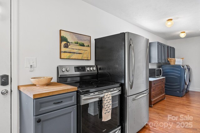 9 Mikayla Ln, Candler, NC 28715 - kitchen featuring appliances with stainless steel finishes, light wood-style floors, washing machine and dryer, gray cabinets, and butcher block counters