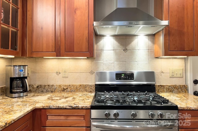 80 Vance Gap Rd, Asheville, NC 28805 - kitchen with gas stove, wall chimney range hood, light stone countertops, glass insert cabinets, and brown cabinets