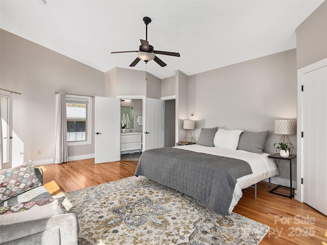 bedroom with a ceiling fan, baseboards, vaulted ceiling, and wood finished floors