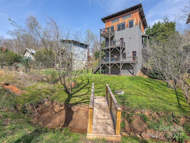 back of house featuring a lawn, stairway, and a balcony