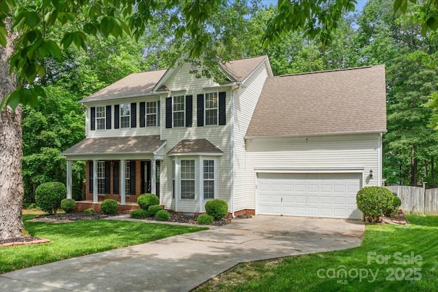 view of front facade featuring a front lawn, driveway, covered porch, fence, and an attached garage