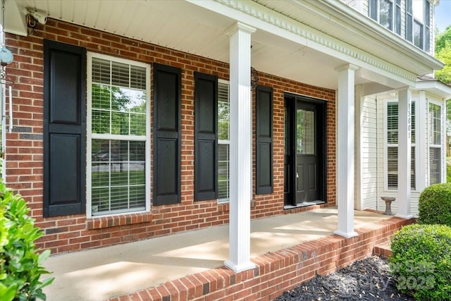 view of home's exterior with a porch and brick siding