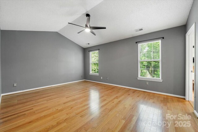 unfurnished bedroom with a textured ceiling, light wood-type flooring, visible vents, and multiple windows