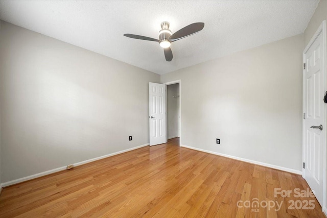 unfurnished room featuring light wood finished floors, a ceiling fan, and baseboards