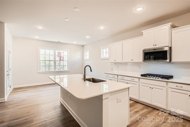 7005 New Town Rd, Waxhaw, NC 28173 - kitchen featuring a sink, stainless steel appliances, light wood finished floors, a kitchen island with sink, and healthy amount of natural light