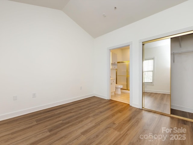 9287 Meadow Vista Rd, Charlotte, NC 28213 - unfurnished bedroom with a closet, light wood finished floors, baseboards, lofted ceiling, and ensuite bath