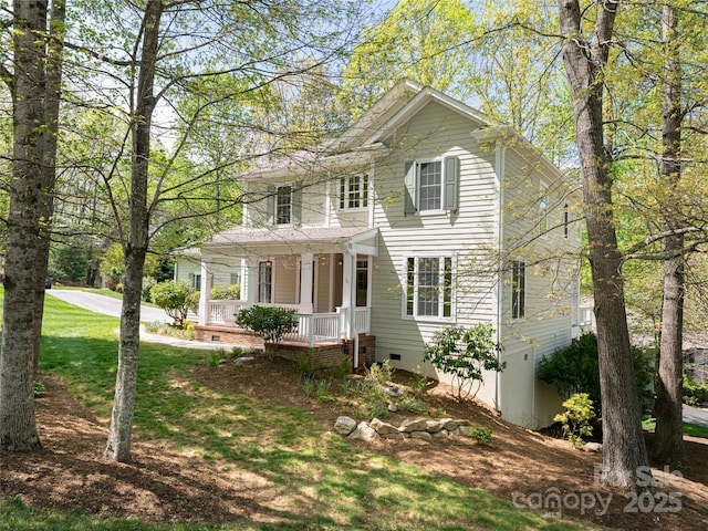 view of front of home with a porch, crawl space, and a front yard