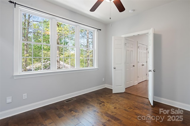 unfurnished bedroom with baseboards, multiple windows, and visible vents