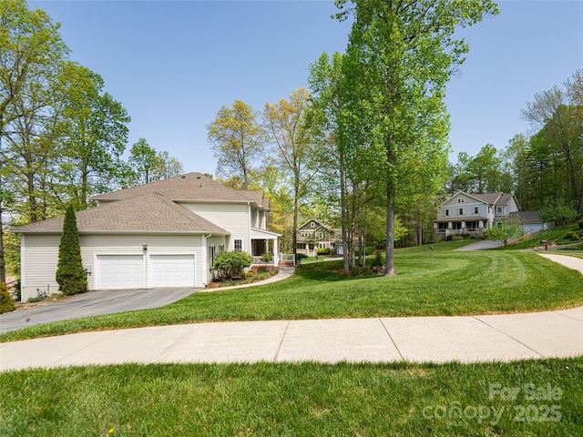 view of front of property with a garage, a front yard, and aphalt driveway