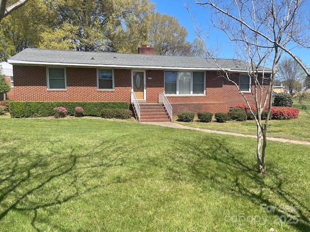 single story home featuring brick siding, a chimney, and a front lawn