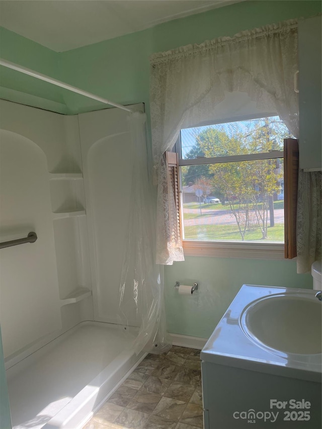 bathroom featuring vanity, baseboards, and a shower with curtain