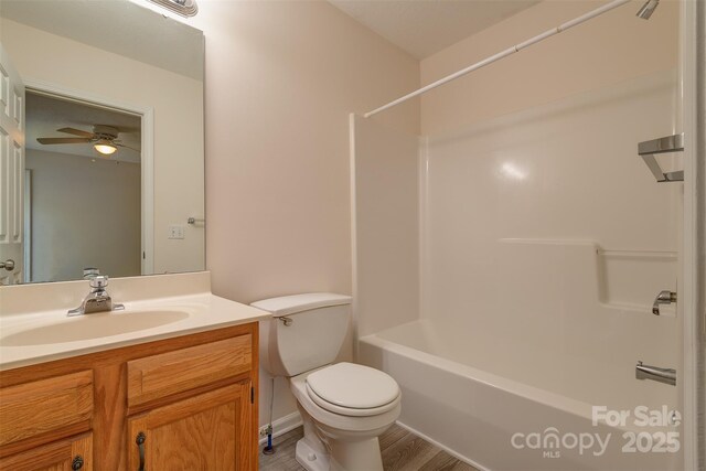 bathroom featuring vanity, wood finished floors, toilet, ceiling fan, and shower / bath combination