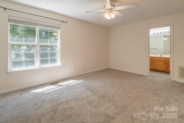 unfurnished bedroom with multiple windows, visible vents, and light colored carpet