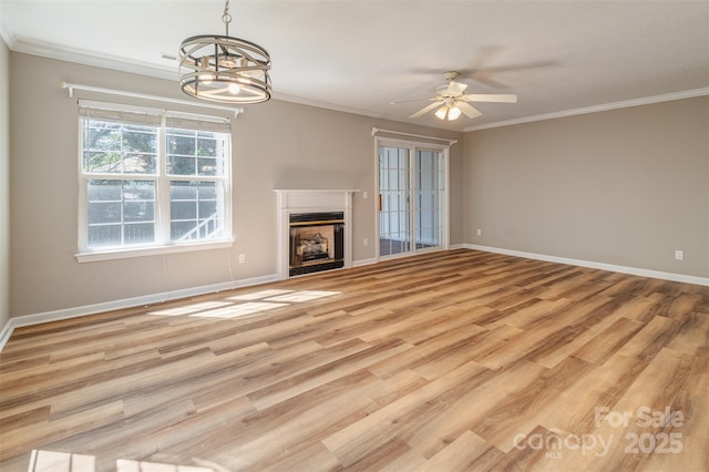 unfurnished living room with baseboards, light wood-style flooring, ceiling fan with notable chandelier, and a fireplace