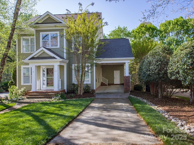 view of front facade with a carport, a front yard, a shingled roof, and concrete driveway