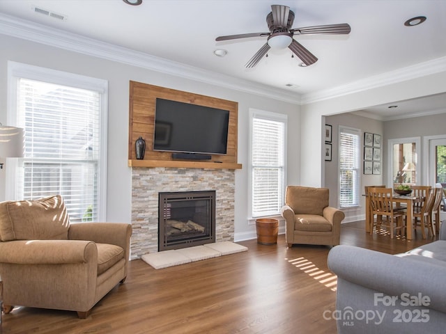 living area featuring ornamental molding, visible vents, ceiling fan, and wood finished floors
