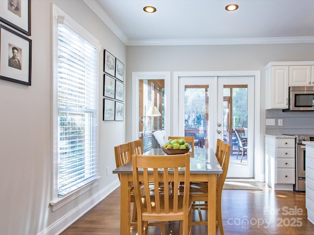 dining space with dark wood-type flooring, french doors, baseboards, and ornamental molding