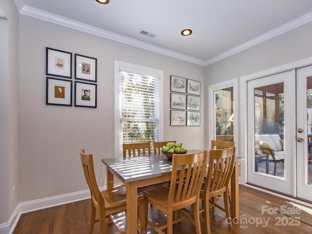 dining room featuring baseboards, french doors, crown molding, visible vents, and wood finished floors