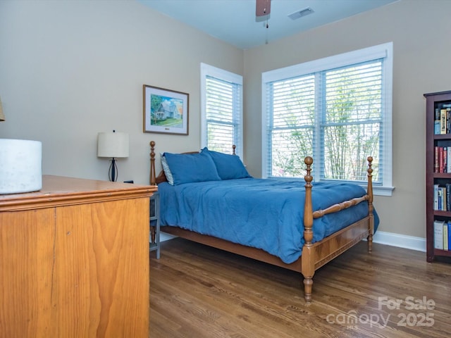 bedroom featuring visible vents, baseboards, and wood finished floors