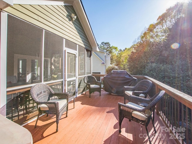 wooden deck with grilling area and a sunroom