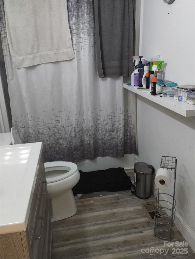 bathroom featuring toilet, wood finished floors, and vanity