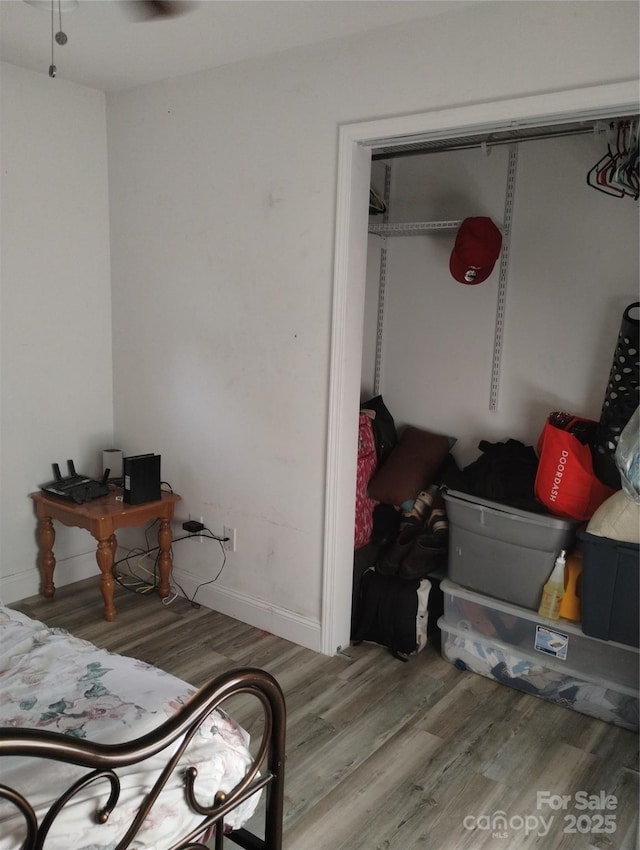 bedroom featuring baseboards, a closet, and wood finished floors