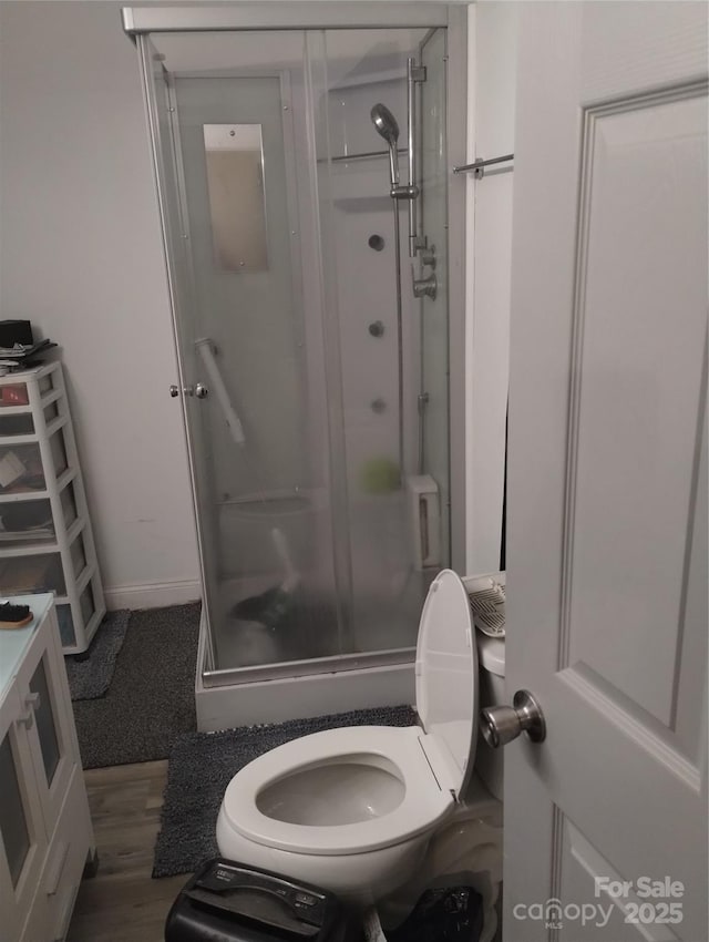 full bathroom with a shower stall, baseboards, and toilet