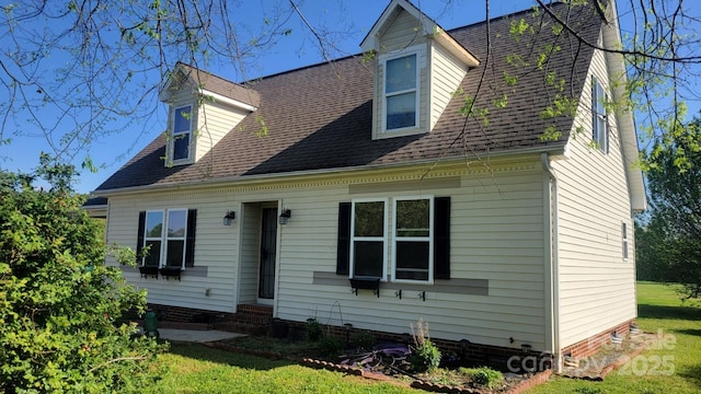 view of front of property with a shingled roof, entry steps, and a front yard