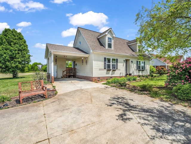cape cod house featuring a front lawn, concrete driveway, crawl space, a carport, and roof with shingles