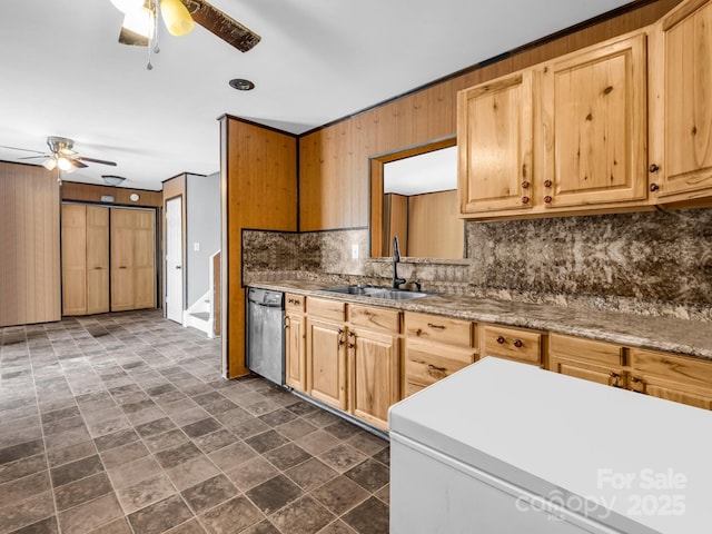 kitchen with stainless steel dishwasher, a sink, tasteful backsplash, a ceiling fan, and stone finish floor