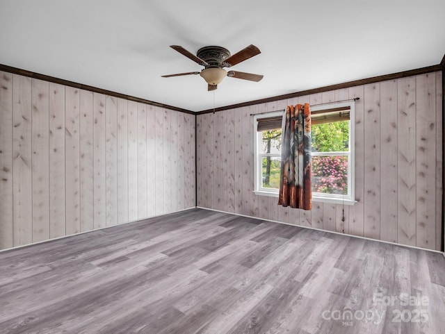 unfurnished room with crown molding, a ceiling fan, and wood finished floors