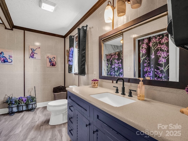 full bathroom featuring toilet, vanity, tile walls, crown molding, and a textured ceiling