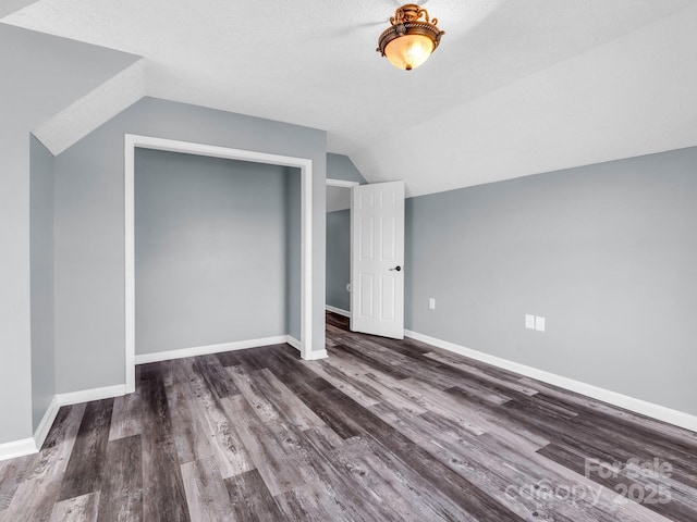 additional living space featuring lofted ceiling, wood finished floors, and baseboards