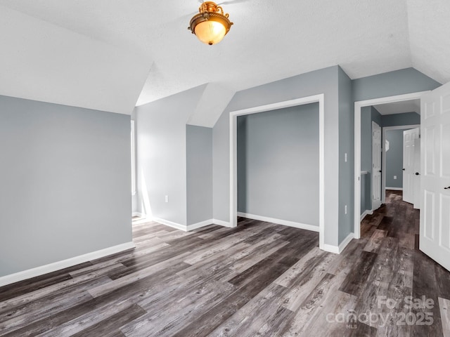 bonus room with vaulted ceiling, wood finished floors, and baseboards