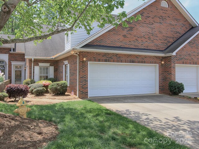 view of front of house with concrete driveway, a shingled roof, an attached garage, and brick siding