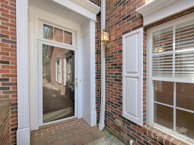 doorway to property featuring brick siding