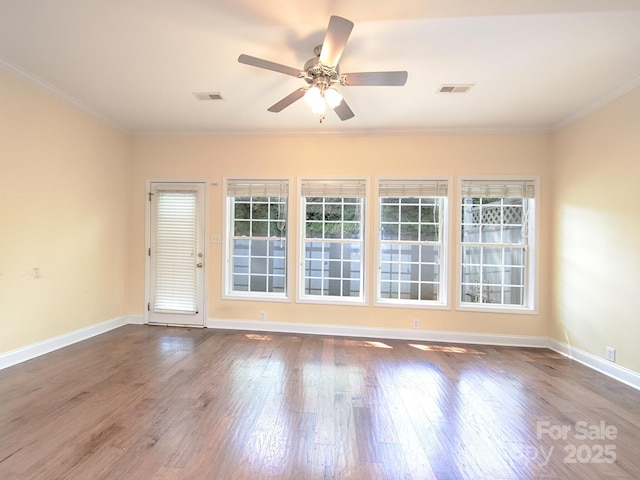 empty room with baseboards, visible vents, wood finished floors, and ceiling fan