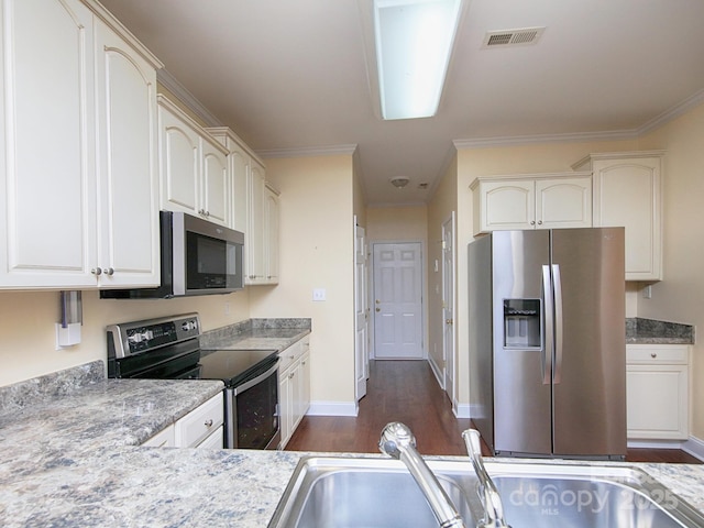 kitchen with crown molding, a sink, appliances with stainless steel finishes, visible vents, and dark wood-style floors