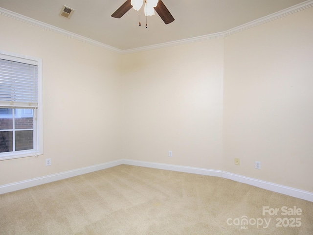 unfurnished room with light colored carpet, a ceiling fan, ornamental molding, and baseboards