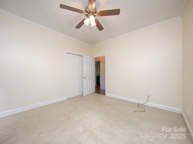 unfurnished bedroom with crown molding, light colored carpet, and baseboards