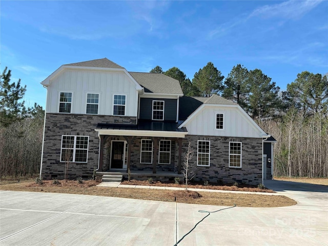 view of front of house with stone siding, covered porch, and board and batten siding